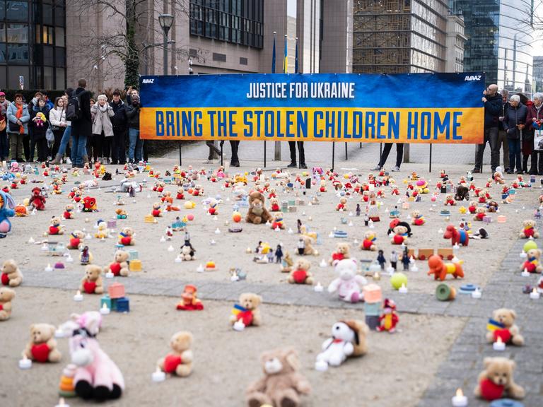 Eine Demonstration für von Russland entführte Kinder in Brüssel. Die US Nichtregierungsorganisation AVAAZ entzündet Kerzen neben Kuscheltieren.