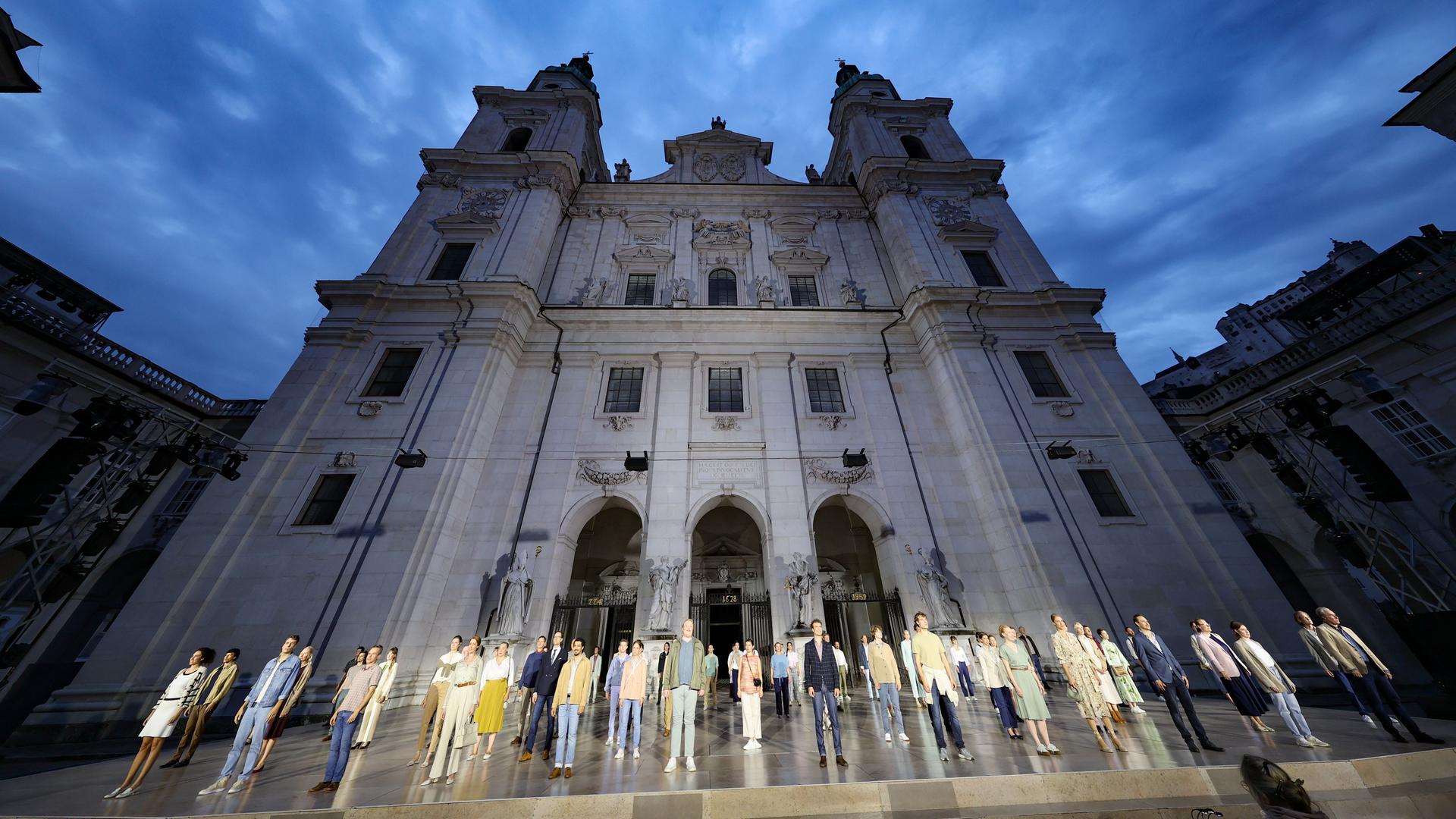 Das Ensemble der Jedermann-Inszenierung steht bei einer Probe auf dem Salzburger Domplatz, dahinter der Dom. Das Ensemble der Jedermann-Inszenierung steht bei einer Probe auf dem Salzburger Domplatz, dahinter der Dom.
