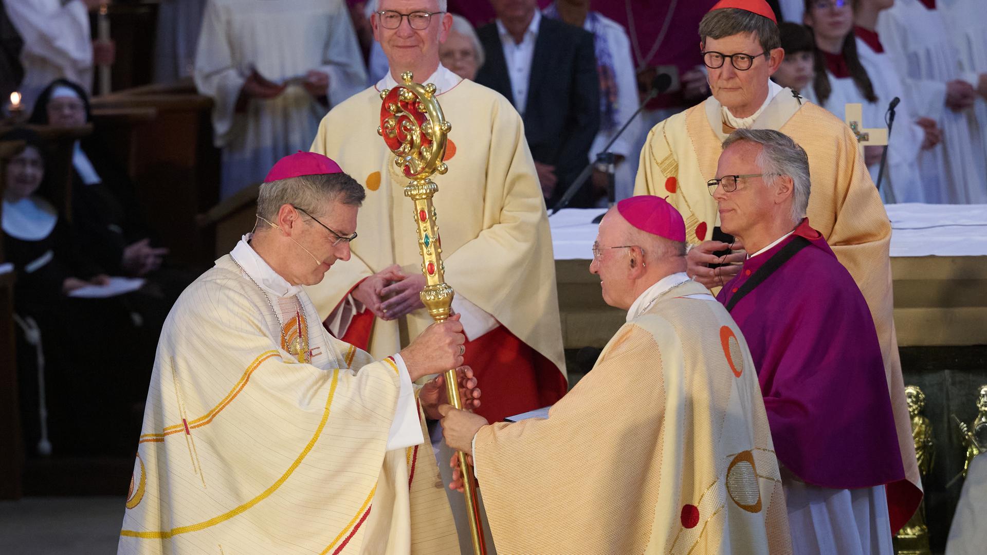 Heiner Wilmer, neuer Bischof von Münster, nimmt von seinem Vorgänger Felix Genn den Bischofsstab entgegen.