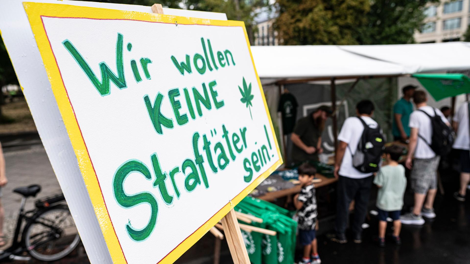 Ein Schild mit der grünen Aufschrift "Wir wollen keine Straftäter sein!" ist im Vordergrund zu sehen. Ein Schild mit der grünen Aufschrift "Wir wollen keine Straftäter sein!" ist im Vordergrund zu sehen.