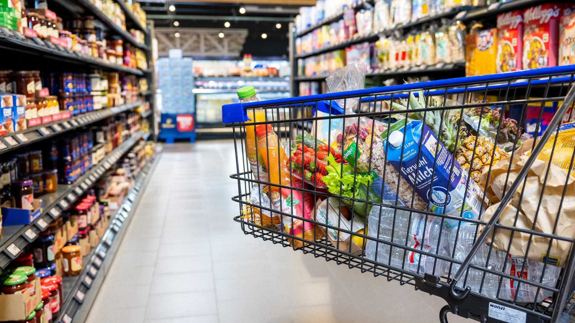 Ein Einkaufswagen mit verschiedenen Lebensmittel in einem Supermarkt.