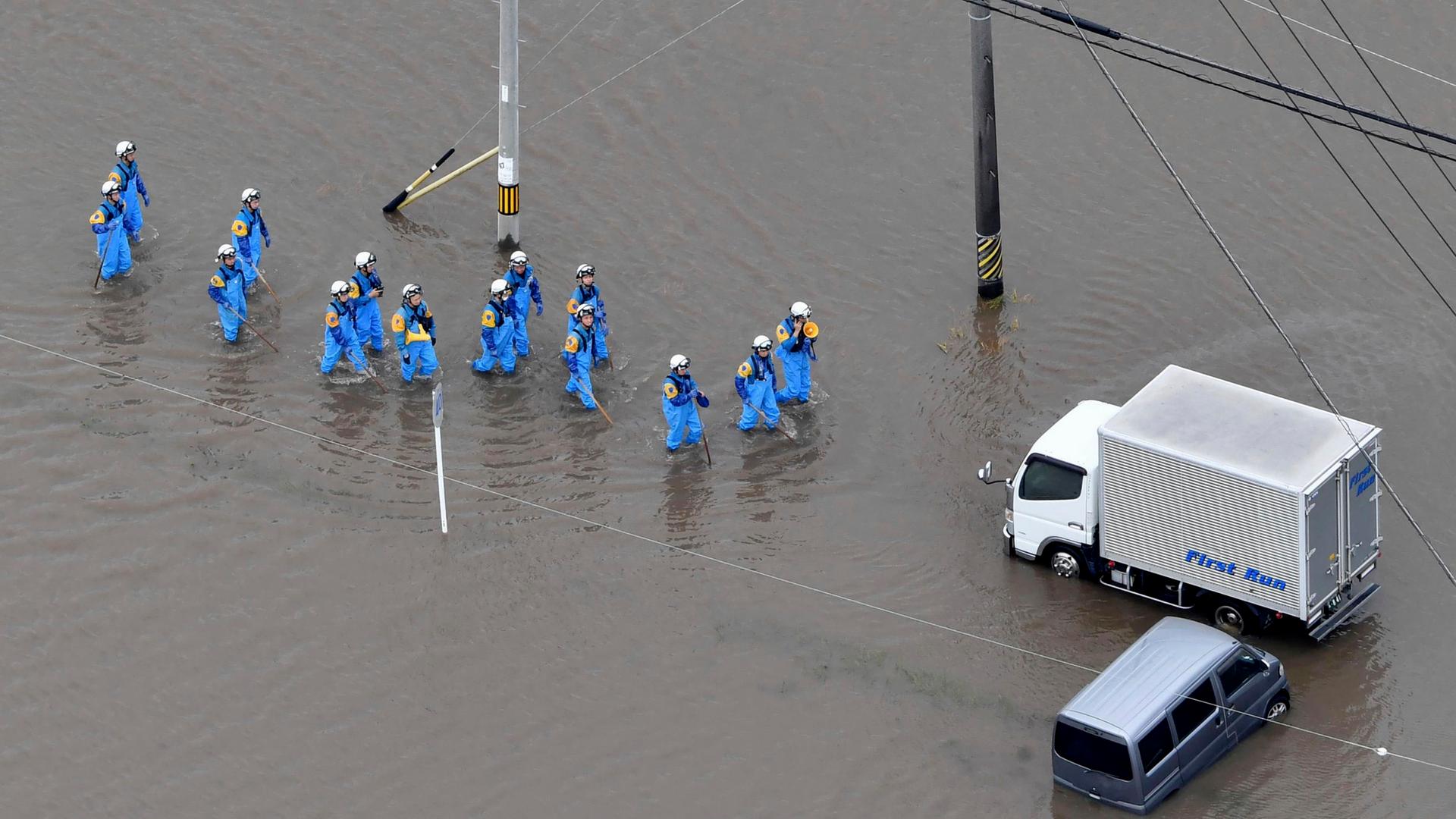Auf diesem Luftbild machen sich Retter nach schweren Unwettern auf den Weg zu überschwemmten Autos in Toyokawa in Japan. Auf diesem Luftbild machen sich Retter nach schweren Unwettern auf den Weg zu überschwemmten Autos in Toyokawa in Japan.