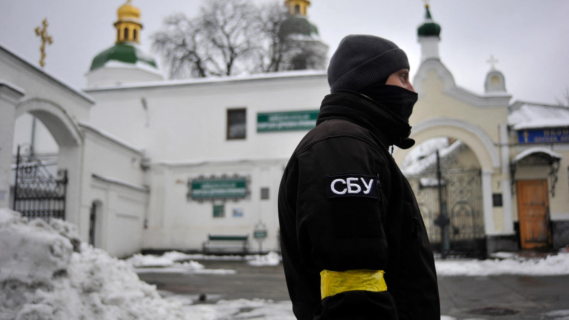 Ein Mitarbeiter des ukrainischen Geheimdienstes SBU steht vor dem Eingang des Kiewer Höhlenklosters. Ein Mitarbeiter des ukrainischen Geheimdienstes SBU steht vor dem Eingang des Kiewer Höhlenklosters.