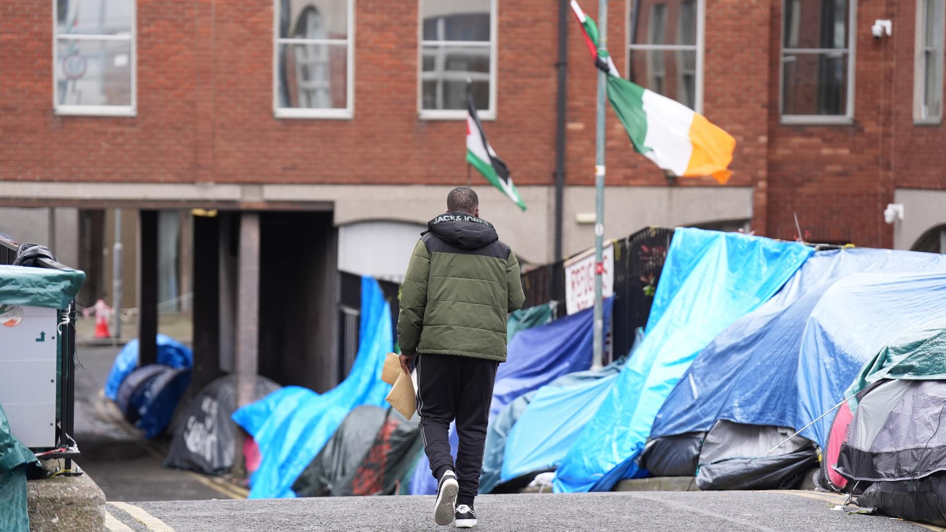  Menschen gehen an Zelten vorbei, in denen Asylbewerber in der Nähe des Internationalen Schutzbüros in Irlands Hauptstadt Dublin hausen.