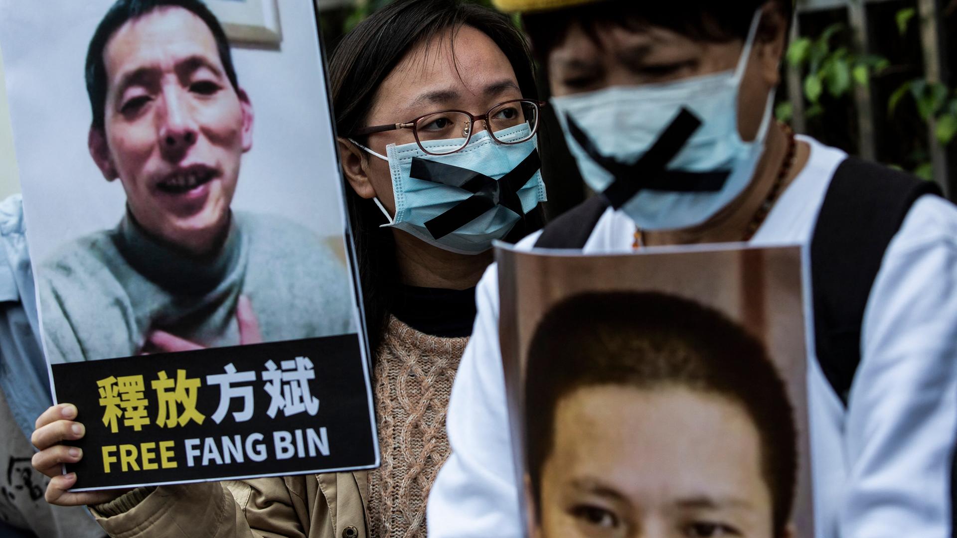 Demonstranten in Hongkong verlangen im Februar 2020 die Freilassung des Bloggers Fang Bin. Sie halten Plakate mit seinem Porträt in die Höhe. Die Demonstranten tragen Corona-Schutzmasken über Mund und Nase, auf die sie schwarze Kreuze geklebt haben. Demonstranten in Hongkong verlangen im Februar 2020 die Freilassung des Bloggers Fang Bin. Sie halten Plakate mit seinem Porträt in die Höhe. Die Demonstranten tragen Corona-Schutzmasken über Mund und Nase, auf die sie schwarze Kreuze geklebt haben.