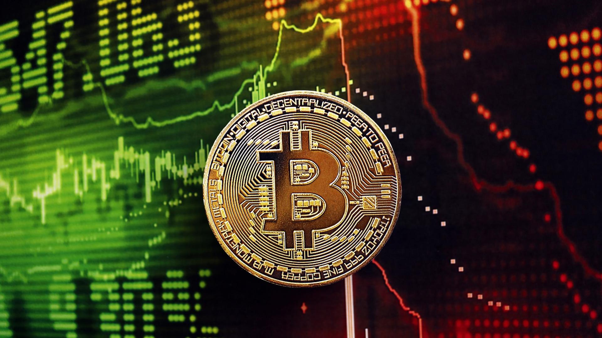 Ein Bitcoin vor einem Monitor