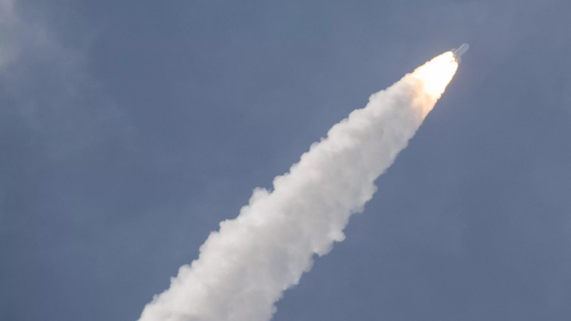 Die neue europäische Trägerrakete Ariane 6 startet am europäischen Weltraumbahnhof in Kourou in Französisch-Guayana erstmals in den Weltraum. Sie ist klein am Himmel zu sehen und zieht einen Schweif aus Rauch hinter sich her.