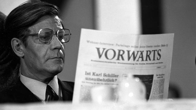 Schwarz-Weiß-Aufnahme von Helmut Schmidt, der konzentriert die Zeitung "Vorwärts" liest