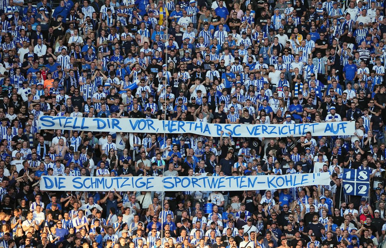 Fans von Hertha BSC halten ein Banner hoch mit der Aufschrift: "Stell Dir vor, Hertha BSC verzichtet auf die schmutzige Sportwetten-Kohle.