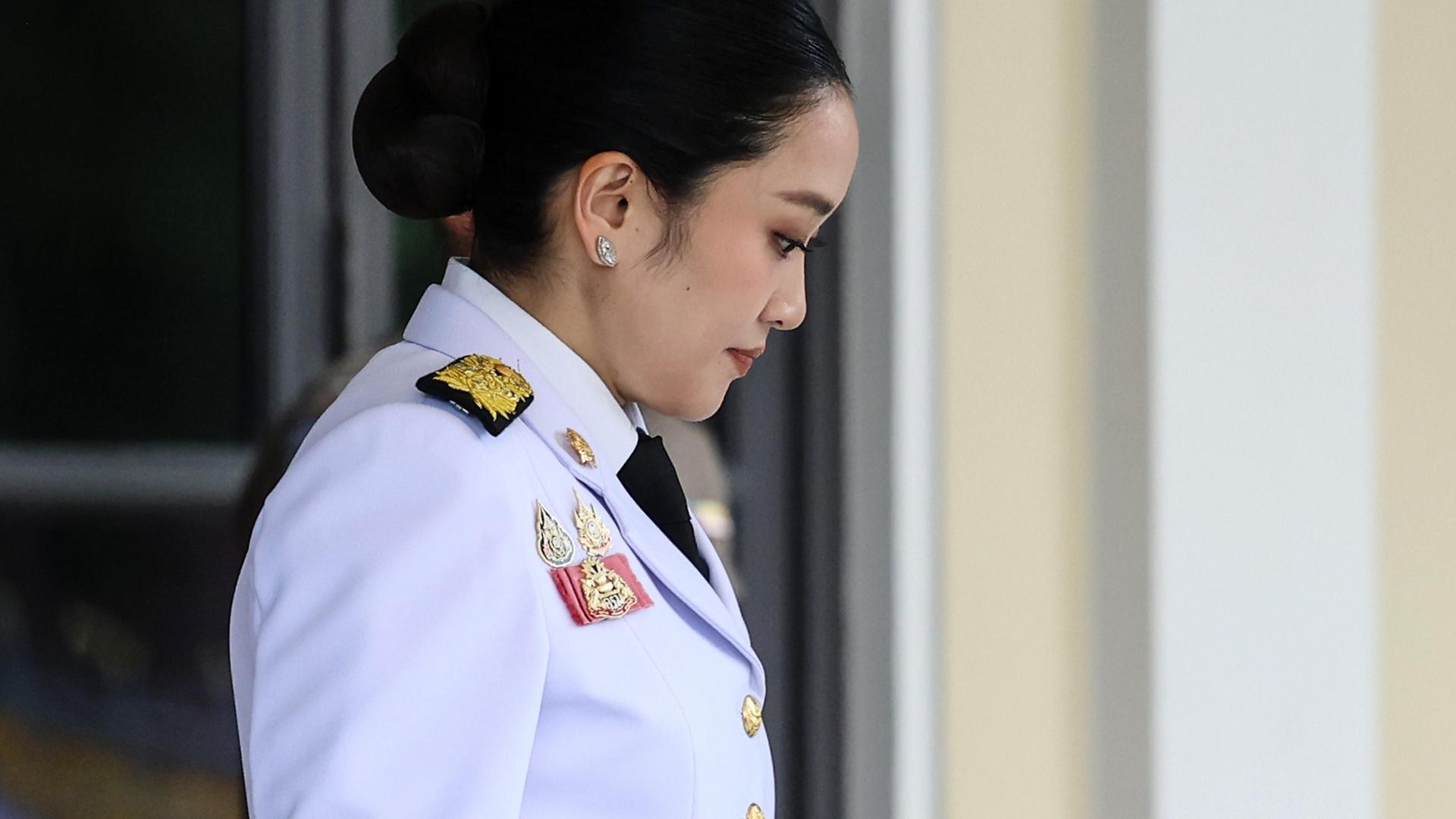 Paetongtarn Shinawatra verlässt in militärischer Uniform das Regierungsgebäude mit gesenktem Kopf. 