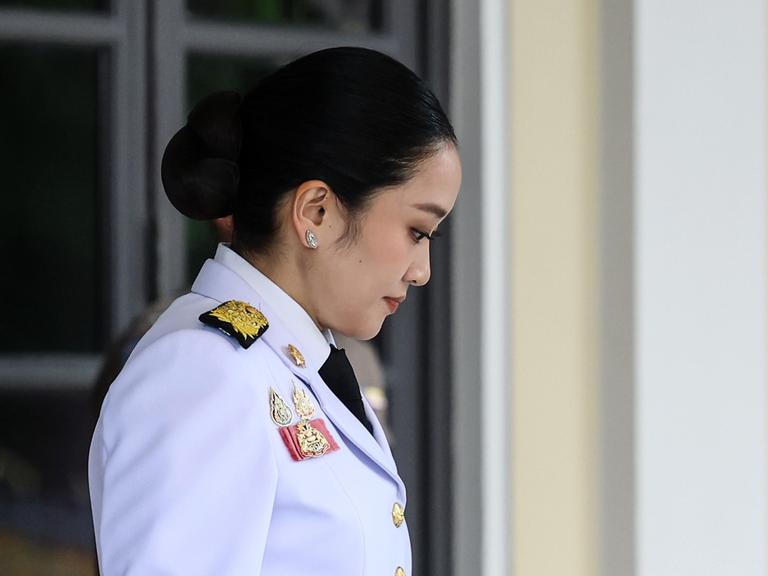 Paetongtarn Shinawatra verlässt in militärischer Uniform das Regierungsgebäude mit gesenktem Kopf. 