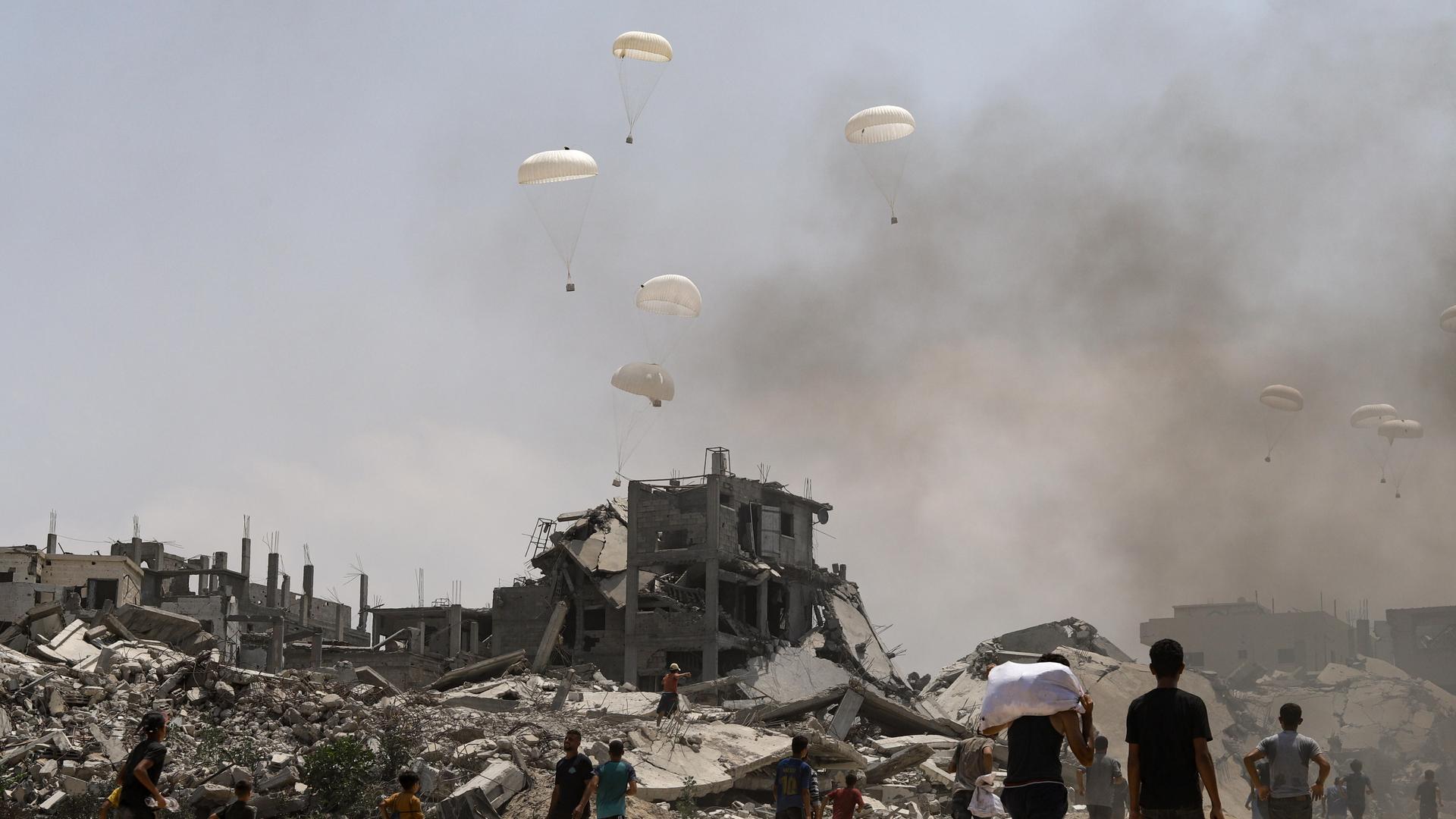 Fallschirme werfen humanitäre Hilfe über dem zerstörten Viertel el-Kerame im Norden des Gazastreifens ab.