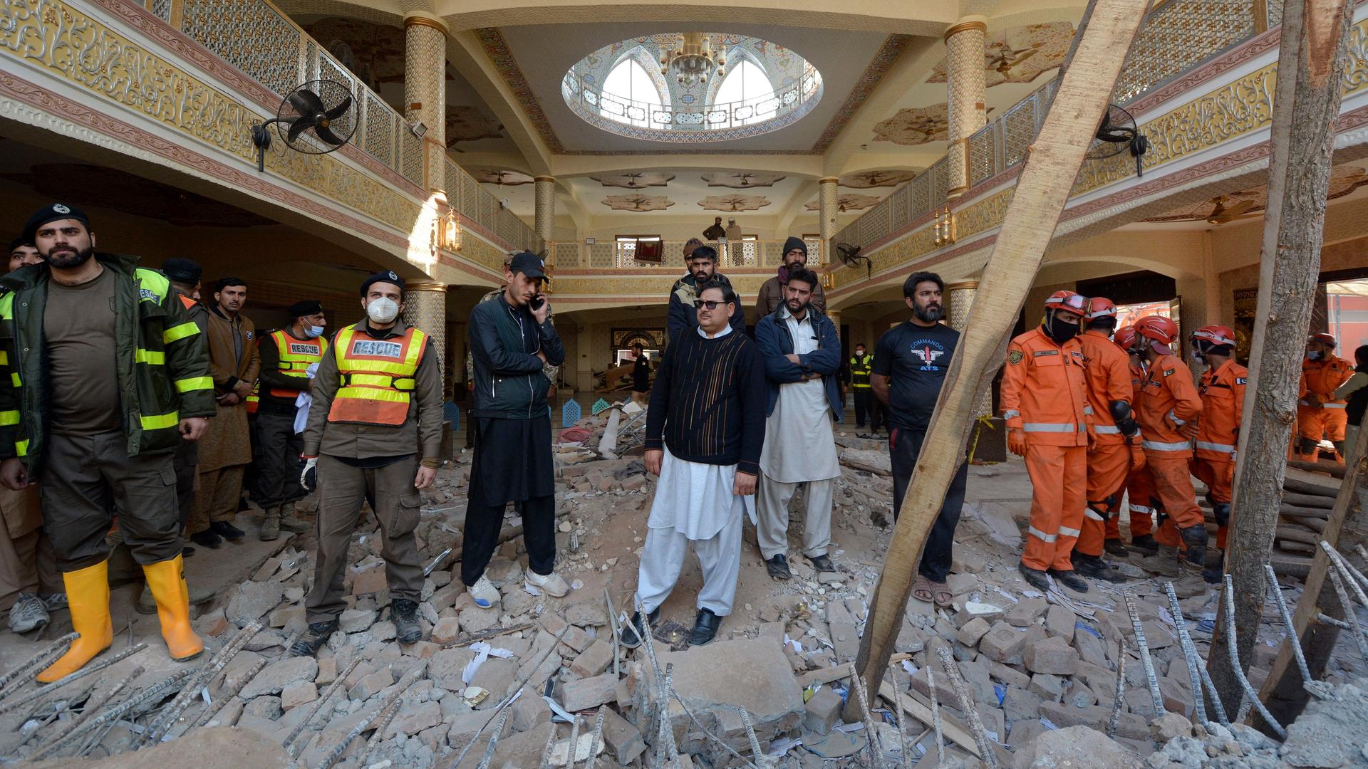 Rettungs-Helfer suchen in den Trümmern von der Moschee nach Opfern.