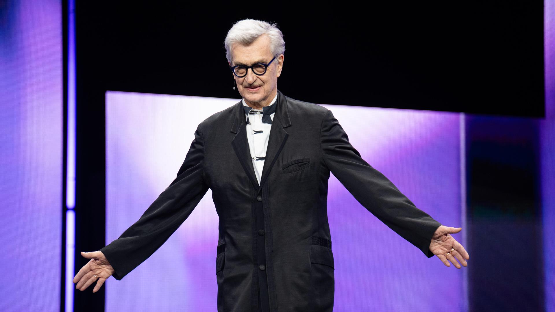 Der Berlinale-Jurypräsident Wim Wenders steht auf der Bühne und breitet die Arme aus. Der Berlinale-Jurypräsident Wim Wenders steht auf der Bühne und breitet die Arme aus.