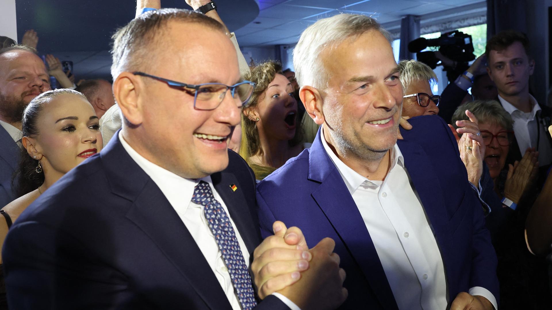 Leif-Erik Holm (AfD, r), Ministerpräsidentenkandidat der AfD und Direktkandidat im Wahlkreis Schwerin, und Tino Chrupalla (vorne l), AfD-Bundesvorsitzender, reagieren auf der Wahlparty seiner Partei in der Eventlocation Seeterasse. Leif-Erik Holm (AfD, r), Ministerpräsidentenkandidat der AfD und Direktkandidat im Wahlkreis Schwerin, und Tino Chrupalla (vorne l), AfD-Bundesvorsitzender, reagieren auf der Wahlparty seiner Partei in der Eventlocation Seeterasse.