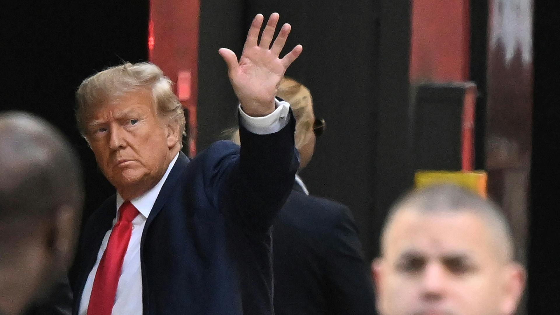 Former US President Donald Trump waves as he arrives at Trump Tower in New York on April 3, 2023. - Trump arrived in New York where he will surrender to unprecedented criminal charges, taking America into uncharted and potentially volatile territory as he seeks to regain the presidency. The 76-year-old Republican, the first US president ever to be criminally indicted, will be formally charged on April 4, 2023 over hush money paid to a porn star during the 2016 election campaign. (Photo by Ed JONES / AFP) / ALTERNATE CROP