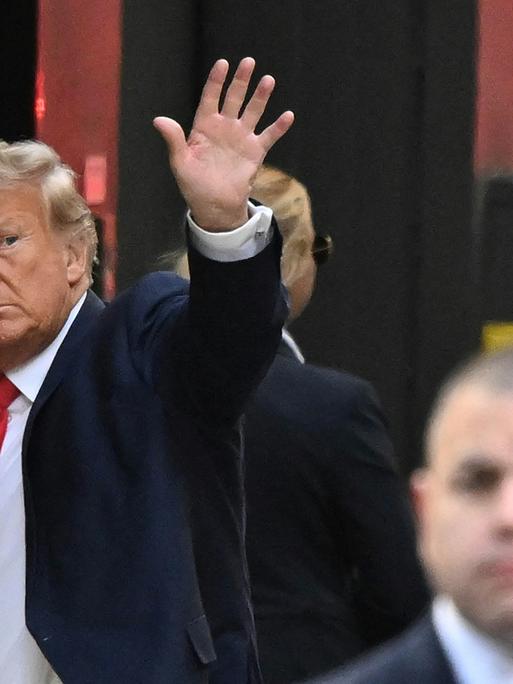 Former US President Donald Trump waves as he arrives at Trump Tower in New York on April 3, 2023. - Trump arrived in New York where he will surrender to unprecedented criminal charges, taking America into uncharted and potentially volatile territory as he seeks to regain the presidency. The 76-year-old Republican, the first US president ever to be criminally indicted, will be formally charged on April 4, 2023 over hush money paid to a porn star during the 2016 election campaign. (Photo by Ed JONES / AFP) / ALTERNATE CROP