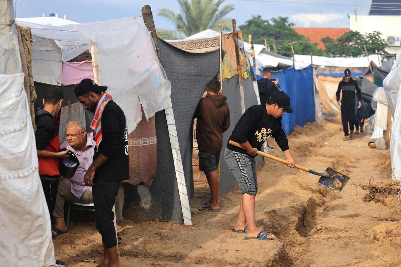 Vertriebene Palästinenser errichten Zelte und versuchen einen Wassergraben zu ziehen.