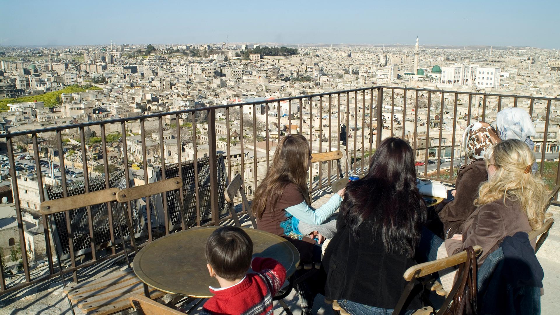 Aleppo vor dem Krieg. Frauen sitzen auf einer Dachterasse und schauen über die Stadt.