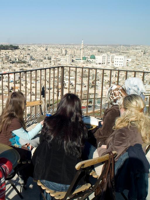 Aleppo vor dem Krieg. Frauen sitzen auf einer Dachterasse und schauen über die Stadt.