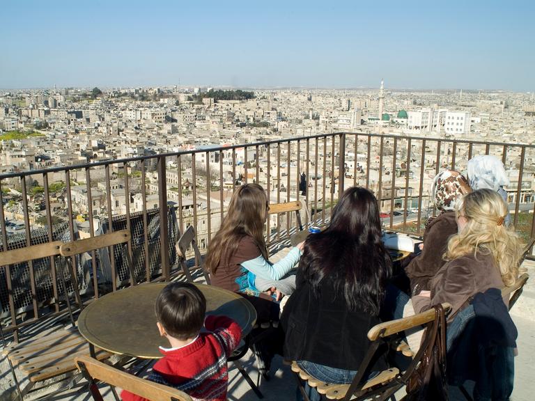 Aleppo vor dem Krieg. Frauen sitzen auf einer Dachterasse und schauen über die Stadt.