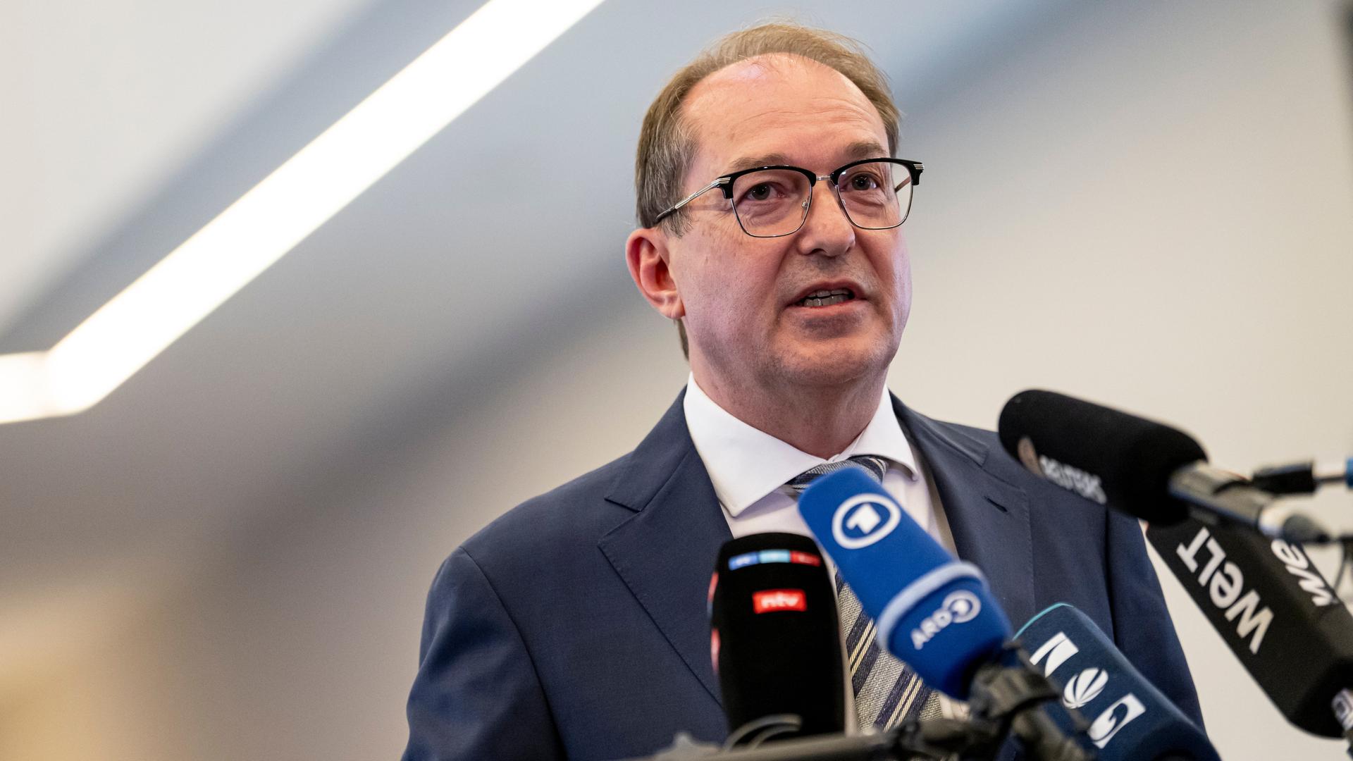 Innenminister Alexander Dobrindt (CSU) steht vor mehreren Mikrofonenn und gibt ein Pressestatement.