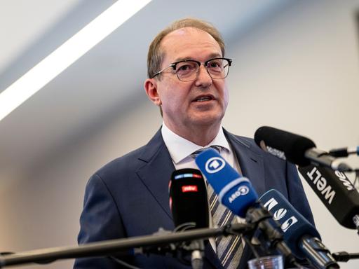 Innenminister Alexander Dobrindt (CSU) steht vor mehreren Mikrofonenn und gibt ein Pressestatement.
