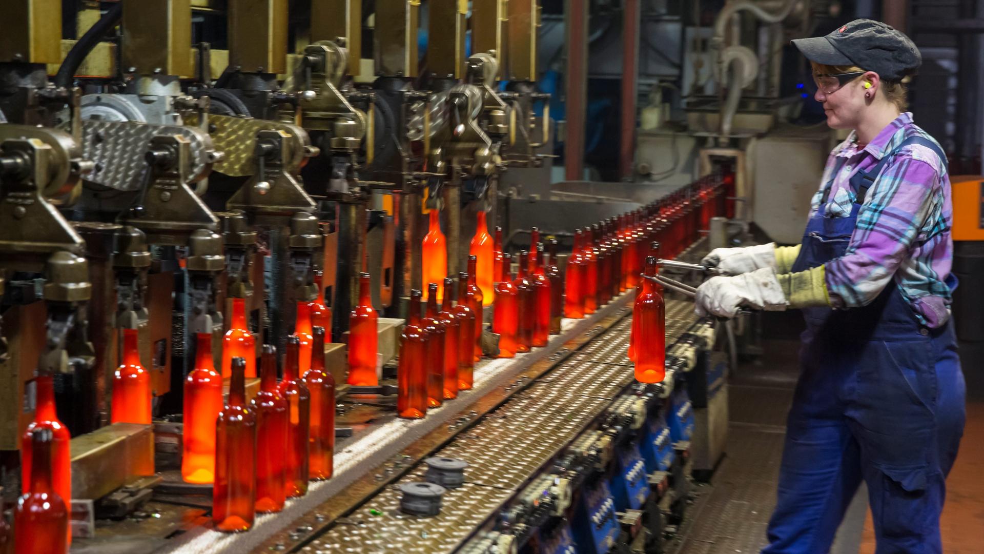Eine Mitarbeiterin entnimmt  in Grossbreitenbach (Thüringen) eine Flasche aus der Glasproduktion bei Wiegand-Glas zur Gewichtskontrolle.