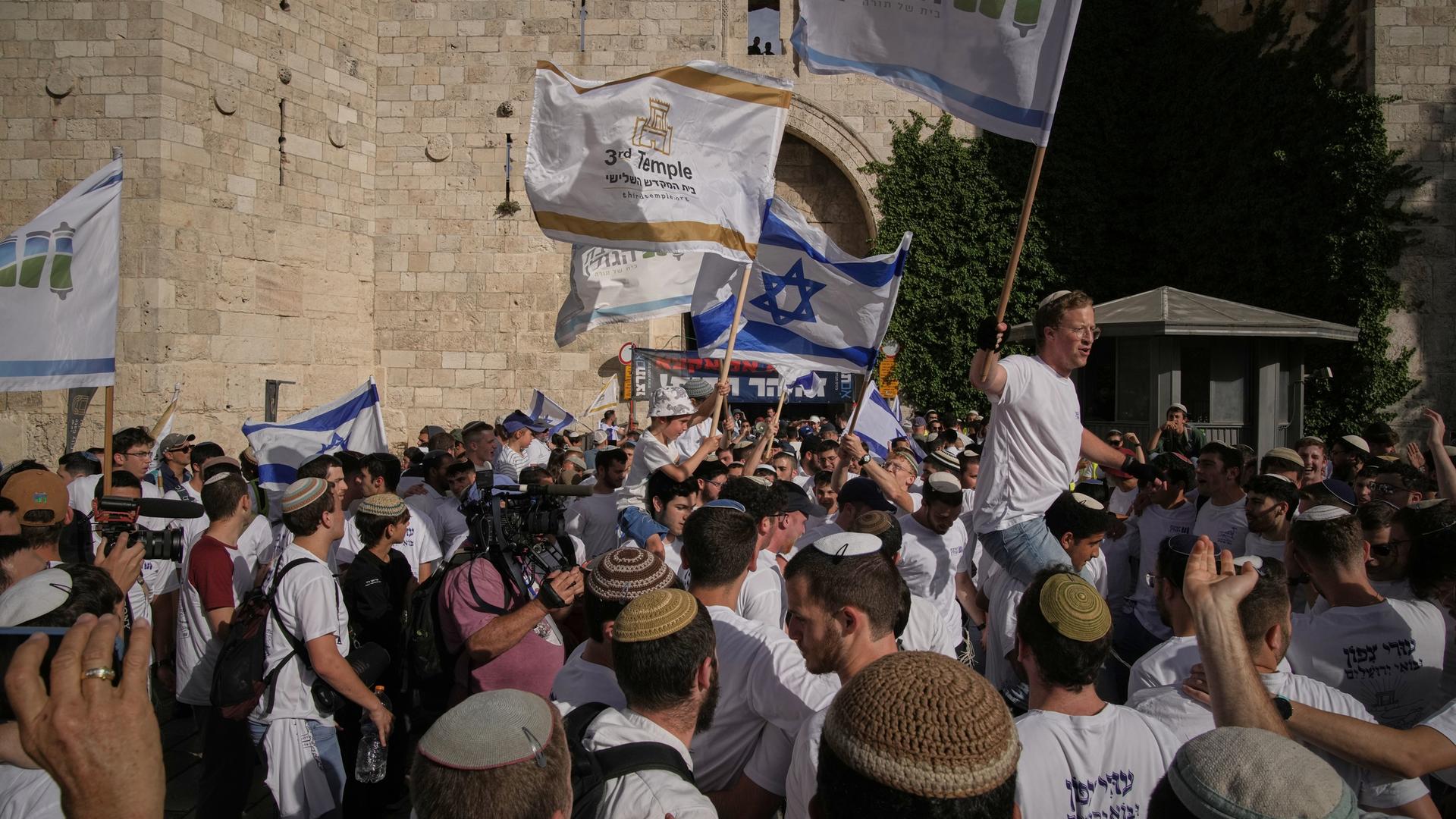 Menschen schwenken israelische Fahnen in der Altstadt von Jerusalem.
