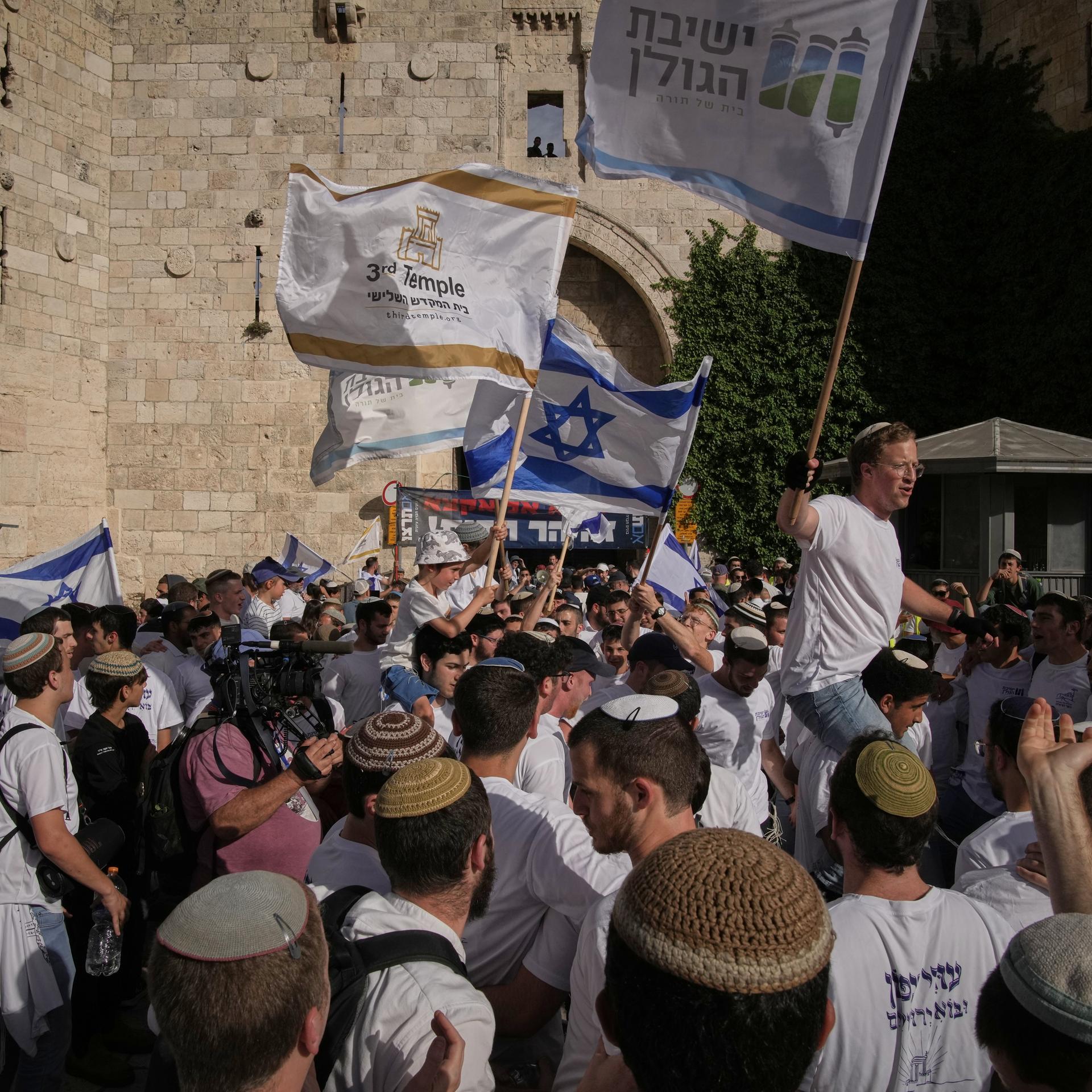 Menschen schwenken israelische Fahnen in der Altstadt von Jerusalem.
