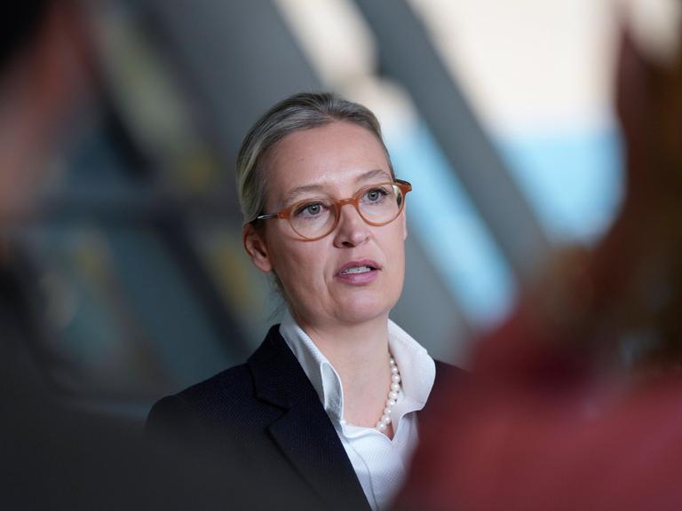 EIn Foto der AfD-Chefin Alice Weidel in Berlin. Sie trägt eine braune Brille, weißes Hemd, Perlenkette und darüber einen schwarzen Blazer.