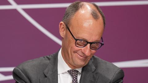 Friedrich Merz (CDU) im Portrait mit einem verschmitzten und schelmischen Grindsen beim Gipfel der CDU/CSU-Bundestagsfraktion