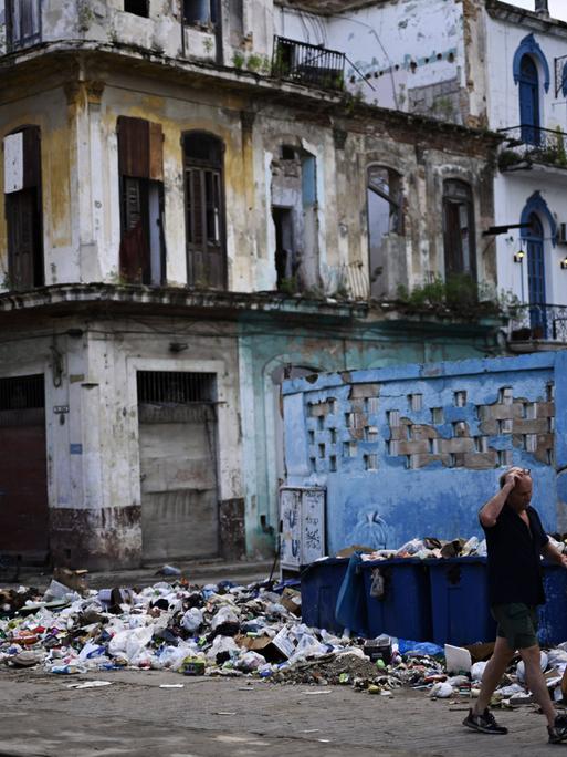 In einer Gasse in Havanna stapelt sich Müll vor einer Haus mit verfallener Fassade.