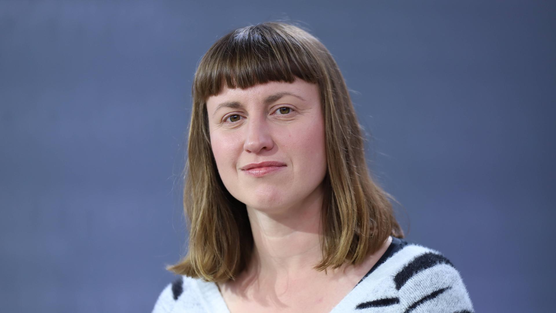 Ein Porträt der Autorin Paula Fürstenberg auf der Leipziger Buchmesse 2024 vor einem blauen Hintergrund