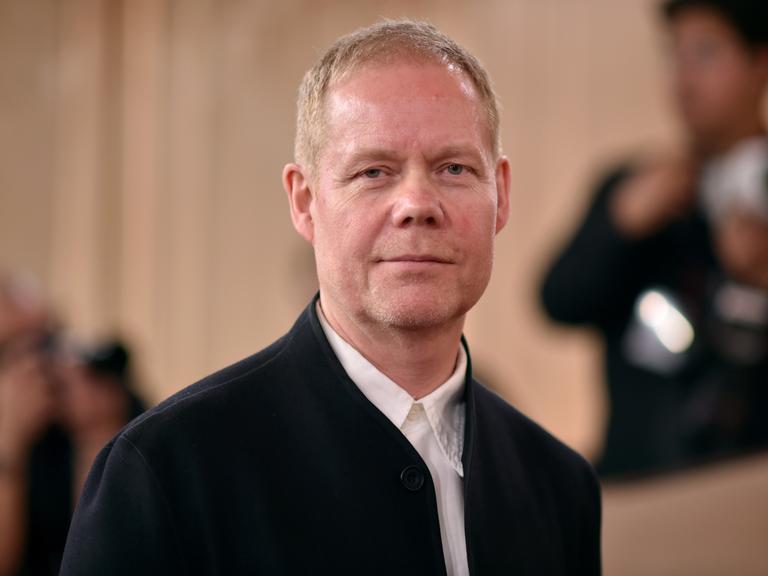 Max Richter schaut in die Kamera und lächelt.