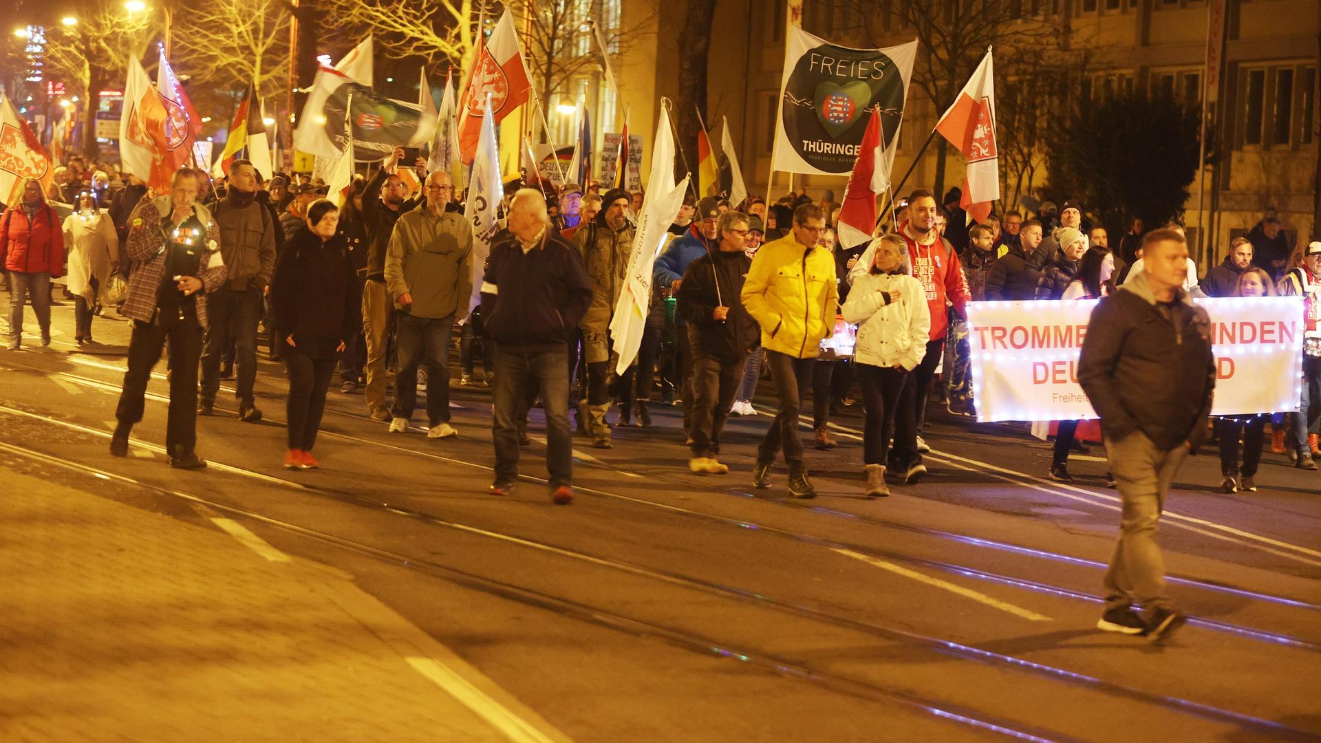 Teilnehmer einer Demonstration laufen durch die Innenstadt von Erfurt. Sie tragen Transparente.