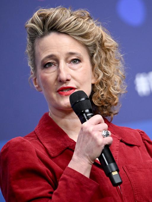 Tricia Tuttle spricht auf einer Bühne in ein Mikrofon.