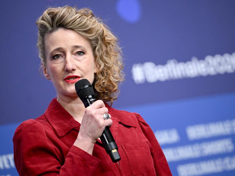 Tricia Tuttle spricht auf einer Bühne in ein Mikrofon.