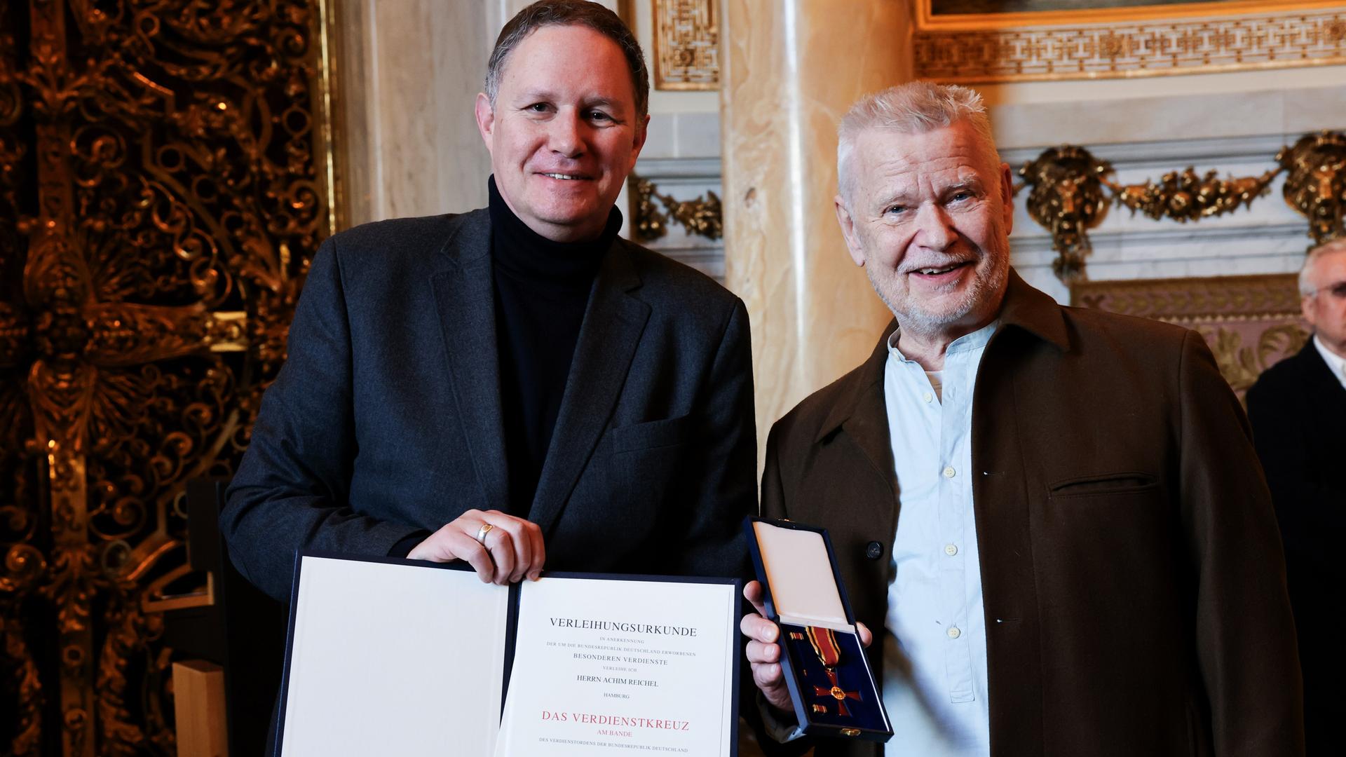 Der Musiker Achim Reichel und Hamburgs Kultursenator Carsten Brosda (SPD, l) stehen bei der feierlichen Verleihung des Bundesverdienstorden der Bundesrepublik Deutschland an Reichel im Turmzimmer im Rathaus.