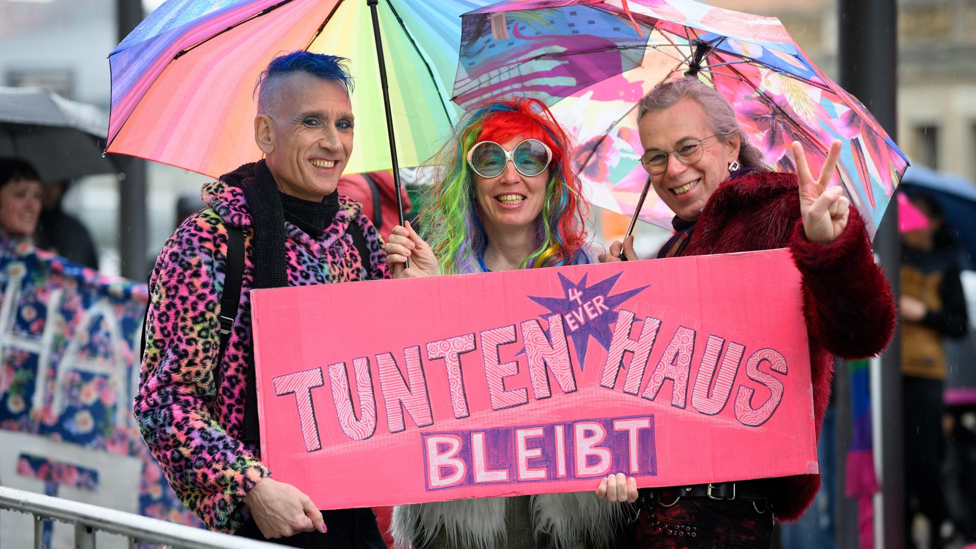 Farbenprächtig gekleidete Demonstranten fordern auf Transparenten den Erhalt des Berliner Tuntenhauses.