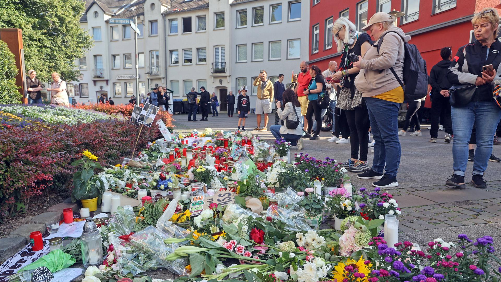 Gedenkstätte mit Trauenden Menschen und Demonstranten.