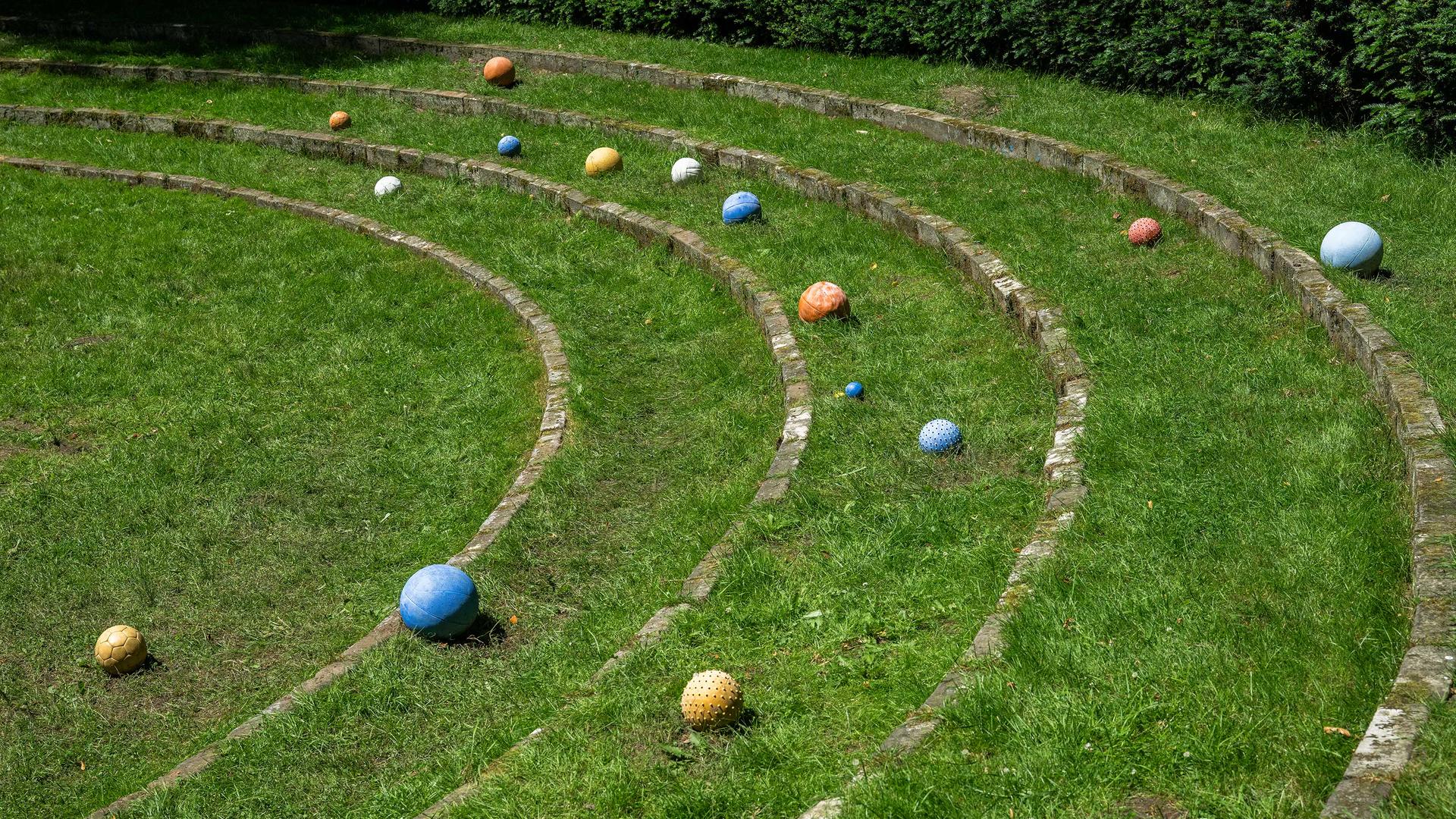 Bunte Sternenkugeln liegen auf einer Wiese im Hamburger Stadtpark