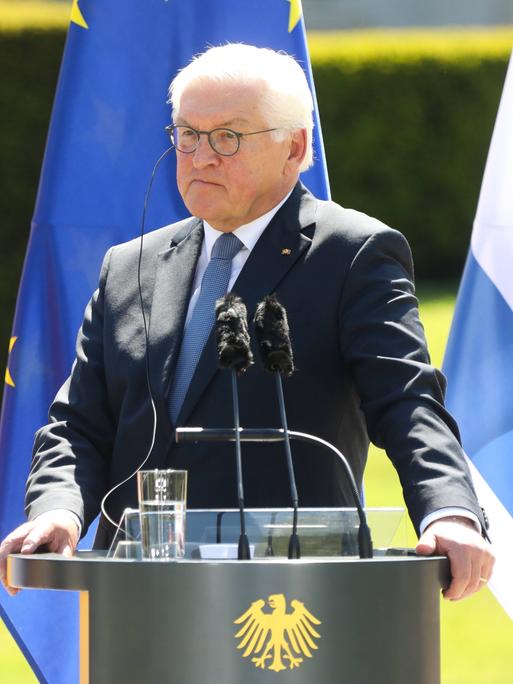 Bundespräsident Frank Walter Steinmeier bei der Pressekonferenz im Schloss Bellevue in Berlin. Er steht an einem Redepult. Hinter ihm sind die deutsche, die israelische und die EU-Flagge zu sehen. 
