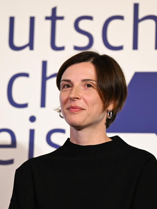 Die Schweizer Autorin Dorothee Elmiger steht bei der Verleihung des Deutschen Buchpreis 2025 auf der Bühne und blickt geradeaus in Richtung Publikum.