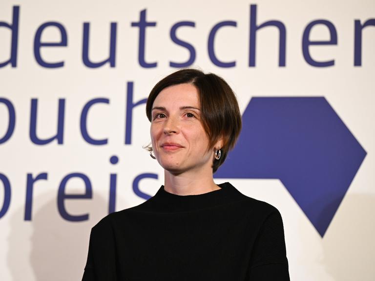 Die Schweizer Autorin Dorothee Elmiger steht bei der Verleihung des Deutschen Buchpreis 2025 auf der Bühne und blickt geradeaus in Richtung Publikum.