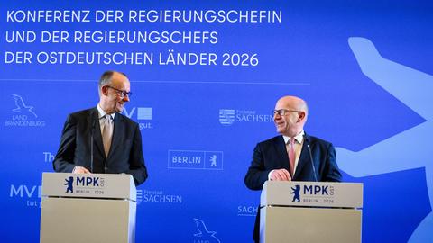 Zu sehen sind Bundeskanzler Friedrich Merz und Kai Wegner, Regierender Bürgermeister von Berlin. Beide schauen sich an und lächeln.