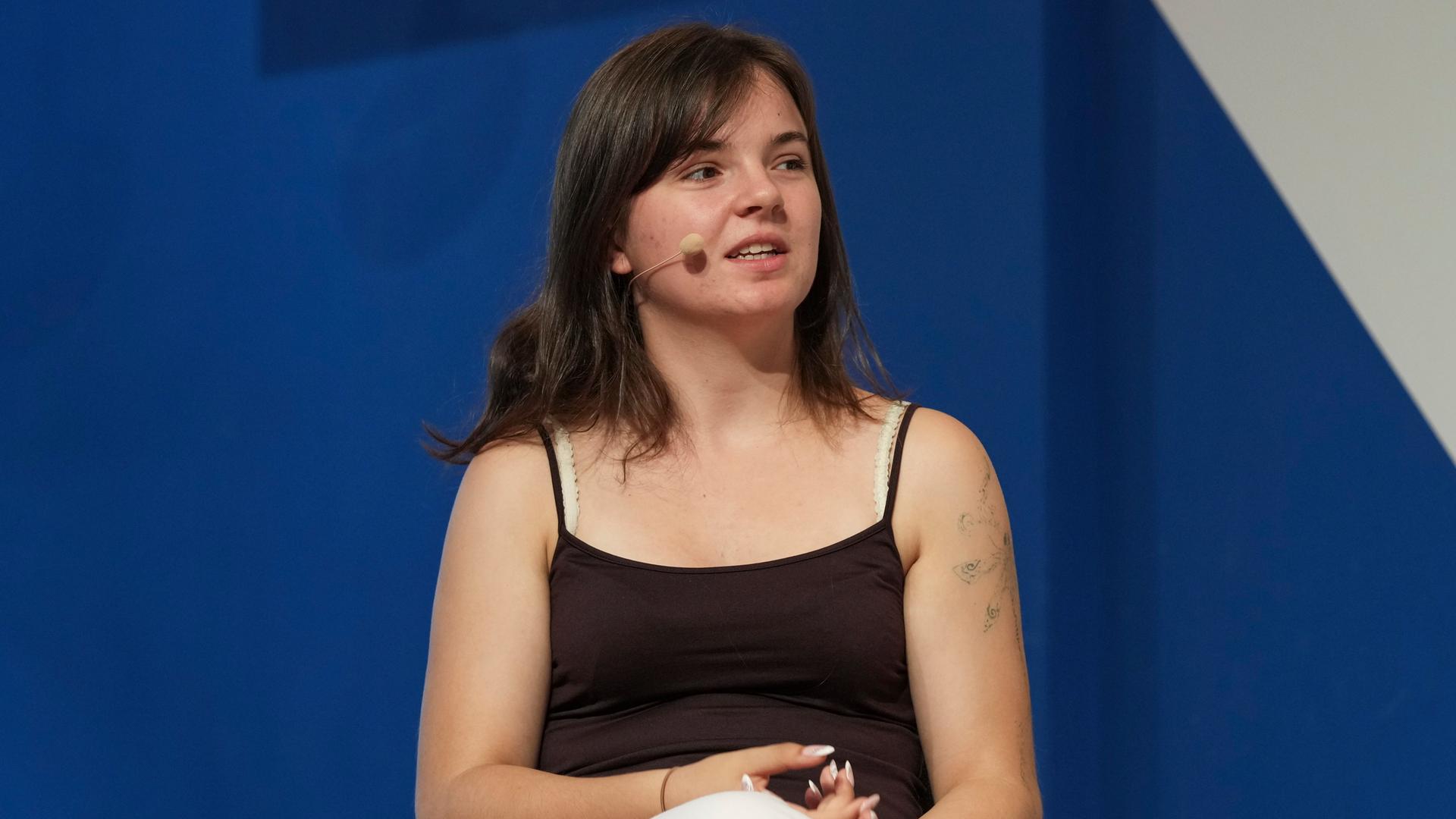Lilli Berthold, stellvertretende Generalsekretärin der Bundesschülerkonferenz, spricht bei einer Veranstaltung auf einem Podium.