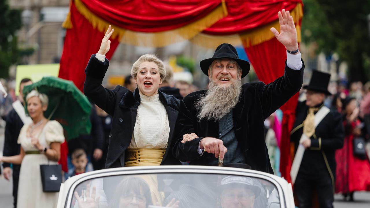 Als Theaterherzog und Helene Freifrau von Heldburg gekleidete Teilnehmer winken beim Festumzug zum 200. Geburtstag von Georg II. von Sachsen-Meiningen aus einem Oldtimer.