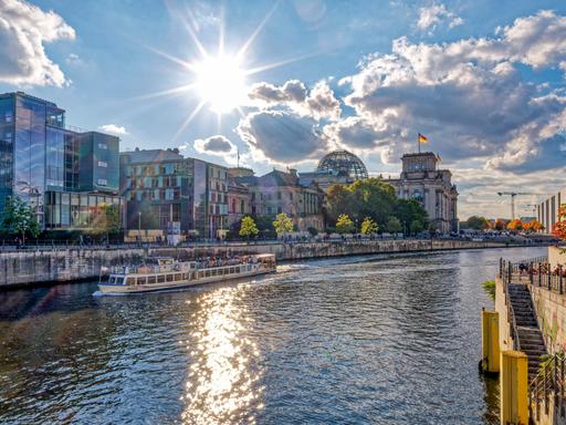 Spreeufer in Herbst mit dem Berliner Reichstag im Hintergrund, die Sonne scheint. Spreeufer in Herbst mit dem Berliner Reichstag im Hintergrund, die Sonne scheint.