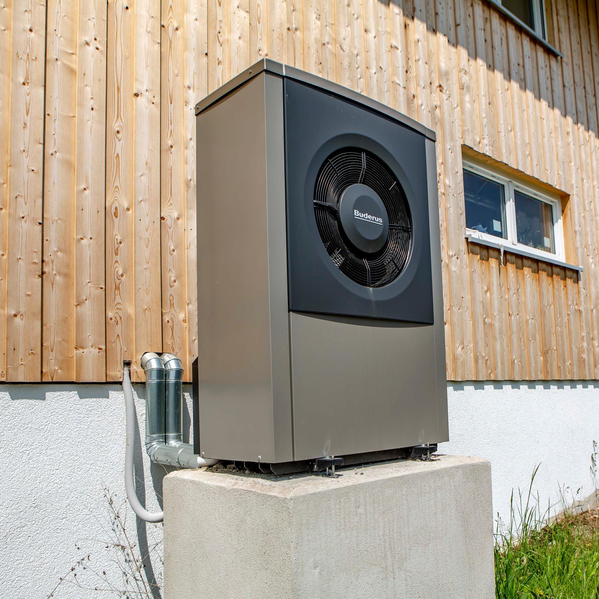 Ein Wärmepume steht an einem Haus  